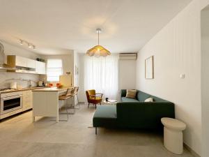 a living room with a green couch and a kitchen at Casa Faria in Stari Grad