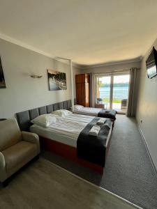 a bedroom with a bed and a couch and a window at Gościniec Rospuda 2 in Augustów