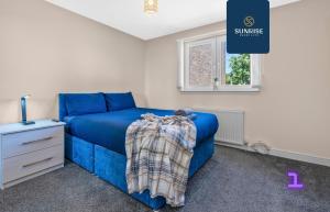 Un dormitorio con una cama azul y una ventana en MUIRTON HOUSE, 4 Bed House, 4 Car Driveway, 2 Bathrooms, Smart TVs in every room, Fully Equipped Kitchen, Large Dining and Living Space, Rear Garden, Free WiFi, Mid to Long Stay Rates Available by SUNRISE SHORT LETS en Dundee