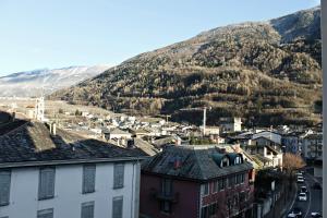 Blick auf eine Stadt mit einem Berg im Hintergrund in der Unterkunft Bed & Rooms , Apartments Corte Rossa in Tirano