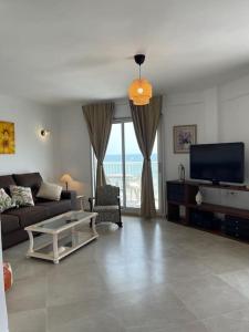 a living room with a couch and a tv at Apartamento con vistas a la Playa con Ascensor y WIFI 9 pax in Daimuz