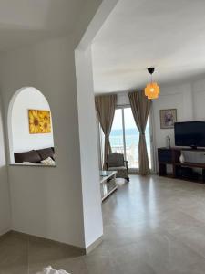 Apartamento Las Meninas Playa con Ascensor y Wifi في دياموز: غرفة معيشة مع غرفة مع أريكة وتلفزيون