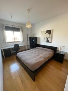 1 dormitorio con 1 cama grande y escritorio en Piso centro de Granada junto al metro, en Granada