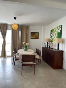 Apartamento Las Meninas Playa con Ascensor y Wifi في دياموز: غرفة طعام مع طاولة وكراسي وغرفة مع طاولة