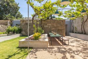 eine Terrasse mit einem Tisch und einer Bank im Hof in der Unterkunft Vandoma Living Suites in Porto