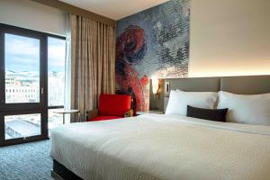 a hotel room with a bed and a red chair at Hotel 43 Boise in Boise