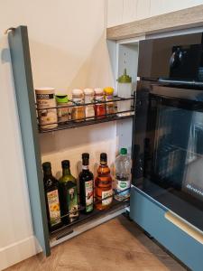 an open refrigerator filled with lots of bottles of alcohol at L'Oiseau vert - calme, ressourçant et proche du centre ville in Montbéliard +8 photos