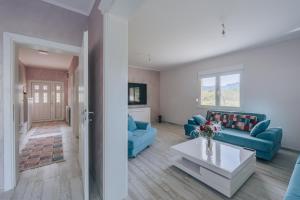 una sala de estar con sofás azules y una mesa. en Apartment Majstorina en Virpazar