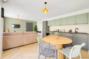 a living room with a table and chairs and a couch at La Joliette, Euromed 2 chambres, 2 salles de bain in Marseille