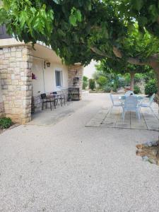 eine Terrasse mit einem Tisch und Stühlen unter einem Baum in der Unterkunft PaulAngela in Avignon