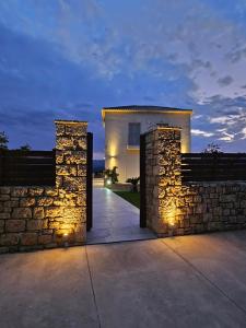 a stone wall with lights in front of a house at Villa Athina in Gythio