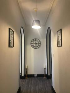 an empty hallway with a clock on the wall at Carlton Hotel in Forres