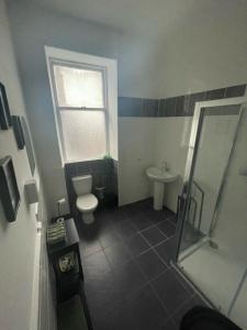 een badkamer met een douche, een toilet en een wastafel bij Carlton Hotel in Forres