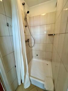La salle de bains est pourvue d'une douche avec rideau de douche. dans l'établissement Gościniec Rospuda 1, à Augustów
