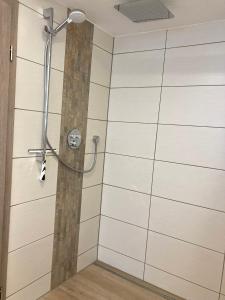 um chuveiro na casa de banho com azulejos brancos em Ferienwohnung "Am Kirchsteig" em Kurort Gohrisch