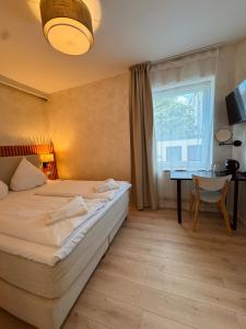 1 dormitorio con cama, escritorio y ventana en dingdong bonn - city apartments, en Bonn