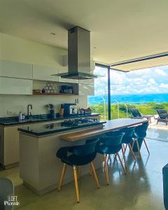 a kitchen with a table with chairs and a large window at LoftMerak in Pereira