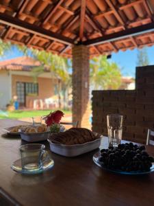 einen Tisch mit drei Teller Essen drauf. in der Unterkunft Bangalô 5 - Praia de Guaratiba-prado/ba in Prado