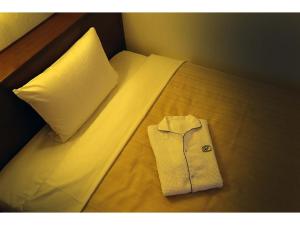 東村山市にあるKumegawa Wing Hotel - Vacation STAY 62973vの枕のあるベッドの上に白いシャツ