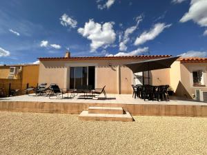 een patio met stoelen en tafels en een huis bij Lion house in Saint-Gilles