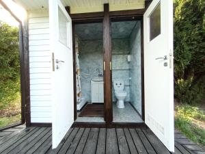 a bathroom with a toilet on a wooden deck at Domek Łukaszówka in Jonkowo +52 photos