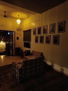 a living room with a couch and pictures on the wall at Nagarik Commune, Baner - Pune in Pune