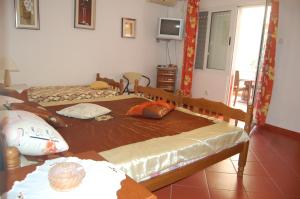 a bedroom with two beds and a television in it at Vila Montenegro in Dobra Voda +17 photos