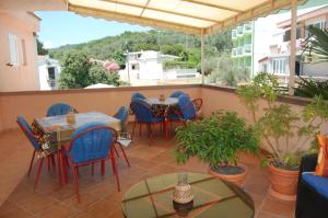 a patio with tables and chairs on a balcony at Vila Montenegro in Dobra Voda