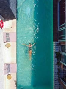 una persona en una piscina en el agua en Mi Amor Boutique Hotel-Adults Only en Tulum