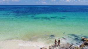 two people standing on the beach near the ocean at Mi Amor Boutique Hotel-Adults Only in Tulum