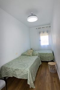 1 dormitorio con 2 camas y ventana en Que vistas, en Granada