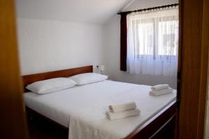 a bedroom with two white towels on a bed at House Private beach in Bibinje