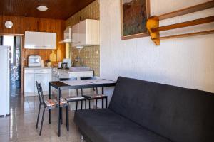 a living room with a couch and a table in a kitchen at House Private beach in Bibinje