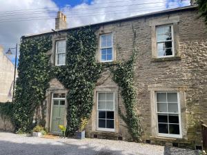 an ivy covered building with windows and doors at SWALEDALE, OLD SCHOOL ROOMS - Luxury Apartment in Richmond, North Yorkshire in Richmond