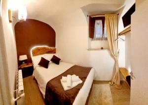 Dimora Grotta Masciarelli في لاكويلا: غرفه فندقيه بسرير ونافذه