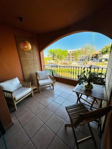a room with a balcony with chairs and a table at La Gavina Loft Xàbia & ARCADE in Jávea +23 photos