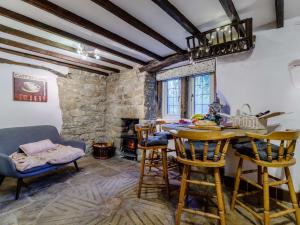 3 Bed in Fritchley 85797 في Crich: غرفة معيشة مع طاولة وكراسي ومدفأة