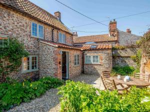 a brick house with a patio and a table at 2 Bed in Holt 78233 in Cley next the Sea