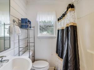 a bathroom with a toilet and a shower curtain at Merry Macaw RP203B in Rockport +32 photos