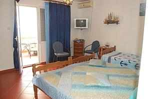 1 dormitorio con cama, TV y balcón en Vila Montenegro, en Dobra Voda