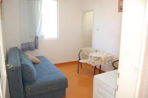 a living room with a blue couch and a table at Vila Montenegro in Dobra Voda