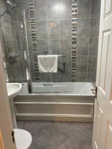 La salle de bains est pourvue d'une douche, d'une baignoire et d'un lavabo. dans l'établissement Towers Hotel Glenbeigh, à Glenbeigh
