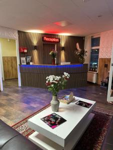 una hall con un tavolo con un vaso di fiori sopra di Flex-Inn a Rotterdam