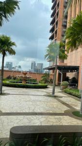 a courtyard with palm trees in front of a building at 100 Service suites At Times Square KL in Kuala Lumpur