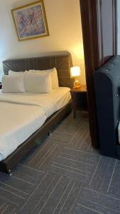a bedroom with a bed and a lamp on a table at 100 Service suites At Times Square KL in Kuala Lumpur