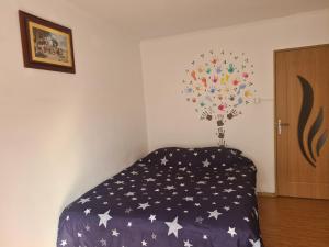 a bedroom with a bed with a blanket with stars at Design Apartment Near Mall 91mp in Bacău +2 photos