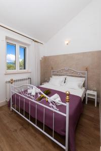 a bedroom with a large bed with purple sheets at VILLA AGAPE - Stone villa on 15k m2 olive grove - Incredible 360 view in Mirce