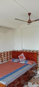 een bed in een kamer met een plafondventilator bij Happy Morning Rohini Homestay in Kurseong