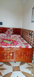 een bed met een houten frame in een kamer bij Happy Morning Rohini Homestay in Kurseong