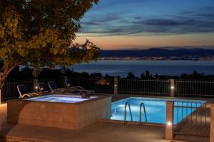 uma piscina com cadeiras e vista para a água em VILLA AGAPE - Stone villa on 15k m2 olive grove - Incredible 360 view em Mirce